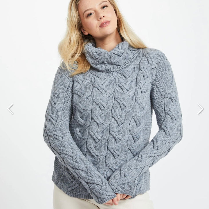 Kinsale 100% Aran Knit Sweater – Timeless Irish Style ☘️

Experience year-round warmth and elegance with the Kinsale Aran Knit Sweater, crafted from super-soft Merino wool by Aran Crafts.

✨ Features:

Iconic Cable Stitch: Bold Aran cable stitching takes center stage, complemented by subtle moss stitch side panels.
Elegant Cowl Neck: Adds a cozy and stylish touch.
Heritage Design: Inspired by the rich history of Aran knitwear, made famous globally in the 1950s.